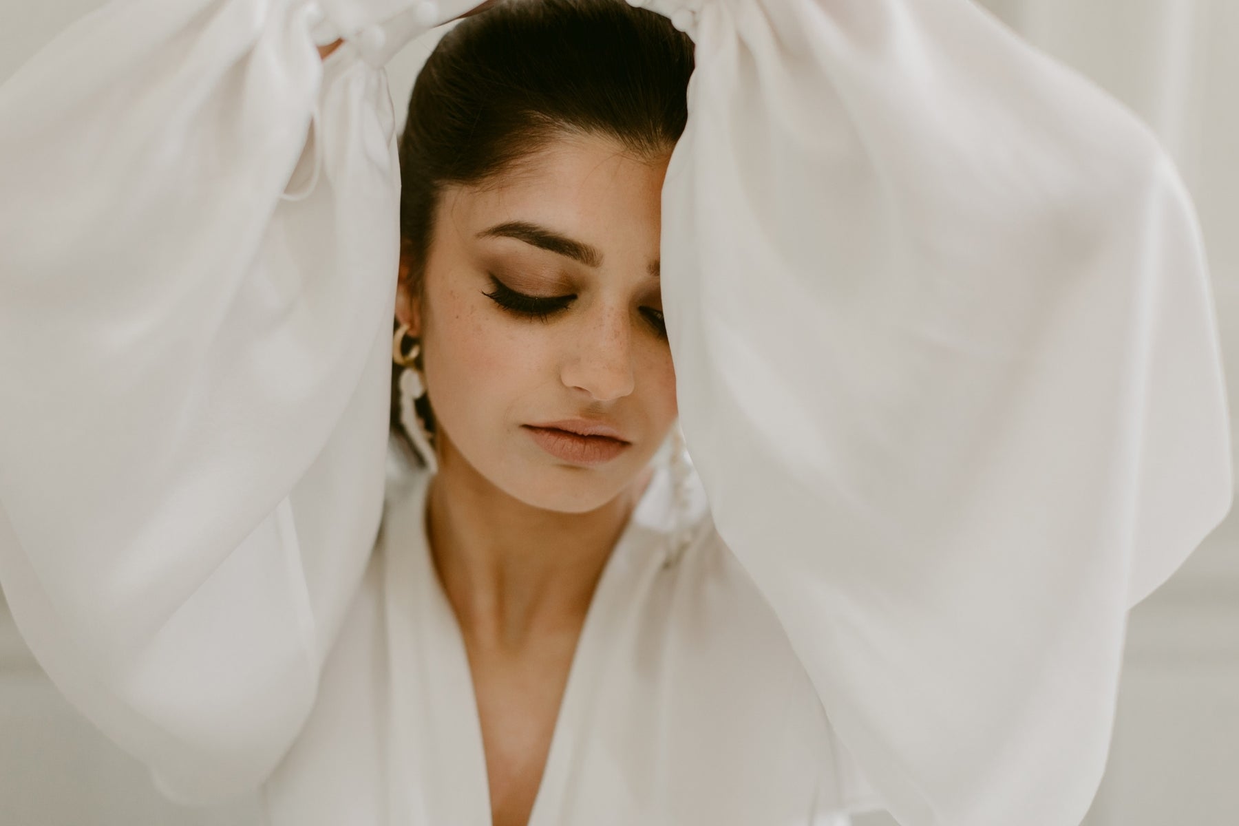Bride wearing statement earrings, editorial portrait