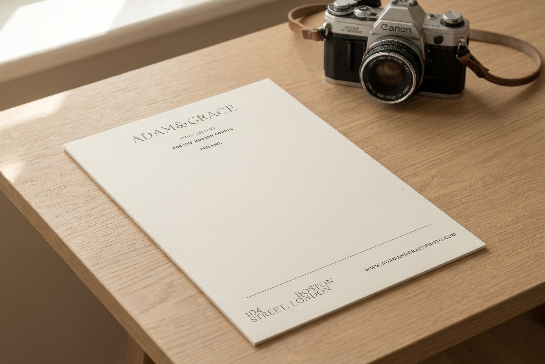 Letterhead on a wooden desk with a camera, stationery for photographers