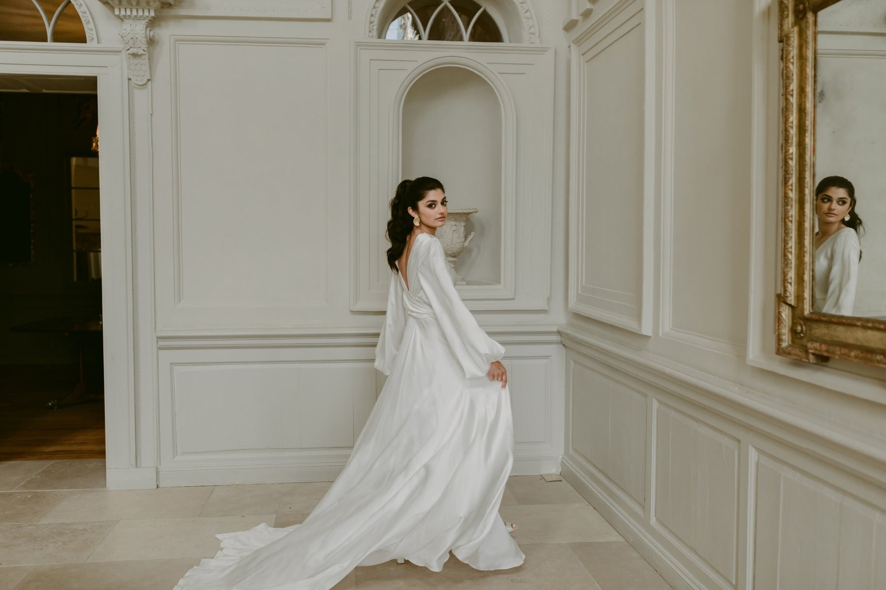 Bride walking through an elegant venue, editorial wedding portrait