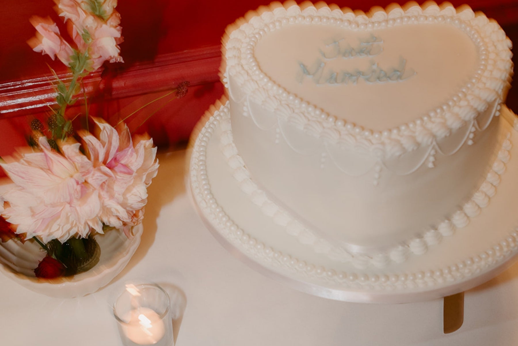 Heart-shaped wedding cake styled with pink florals