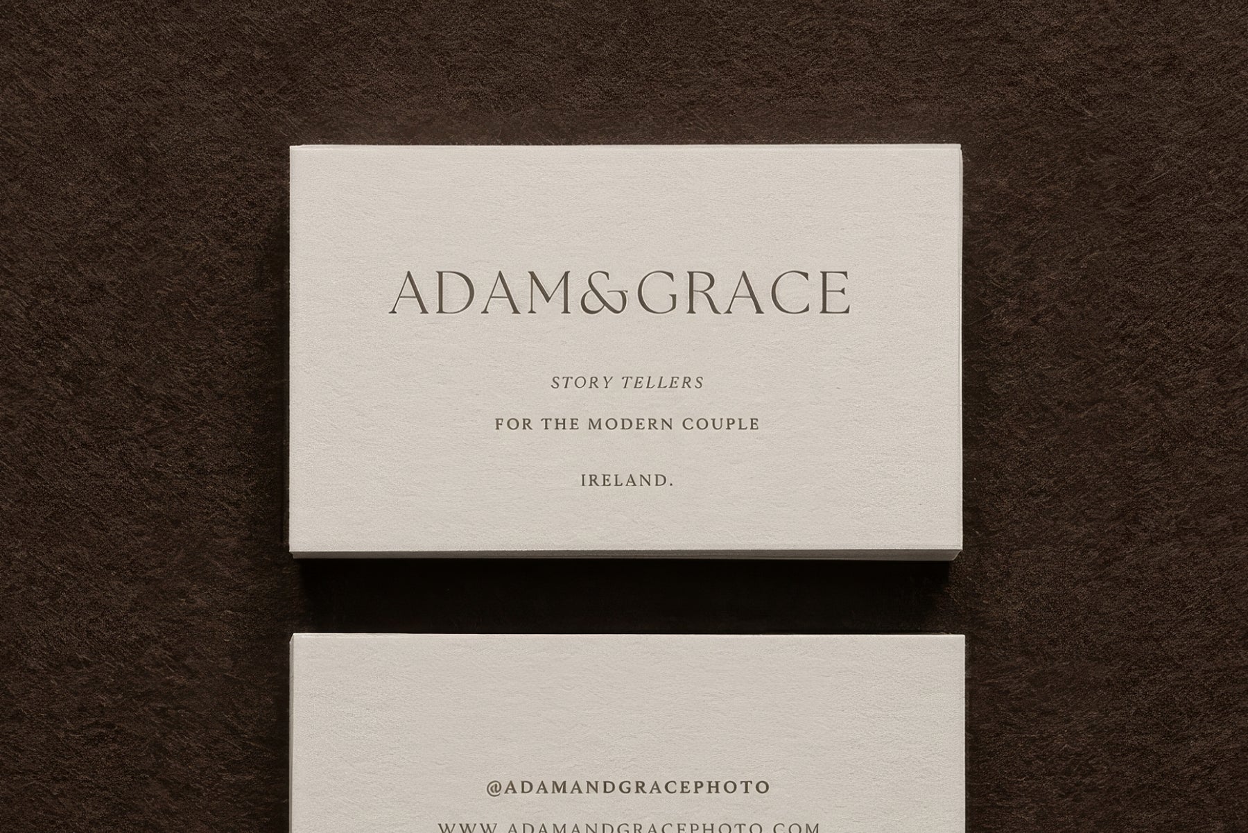 Adam and Grace business cards on a brown surface